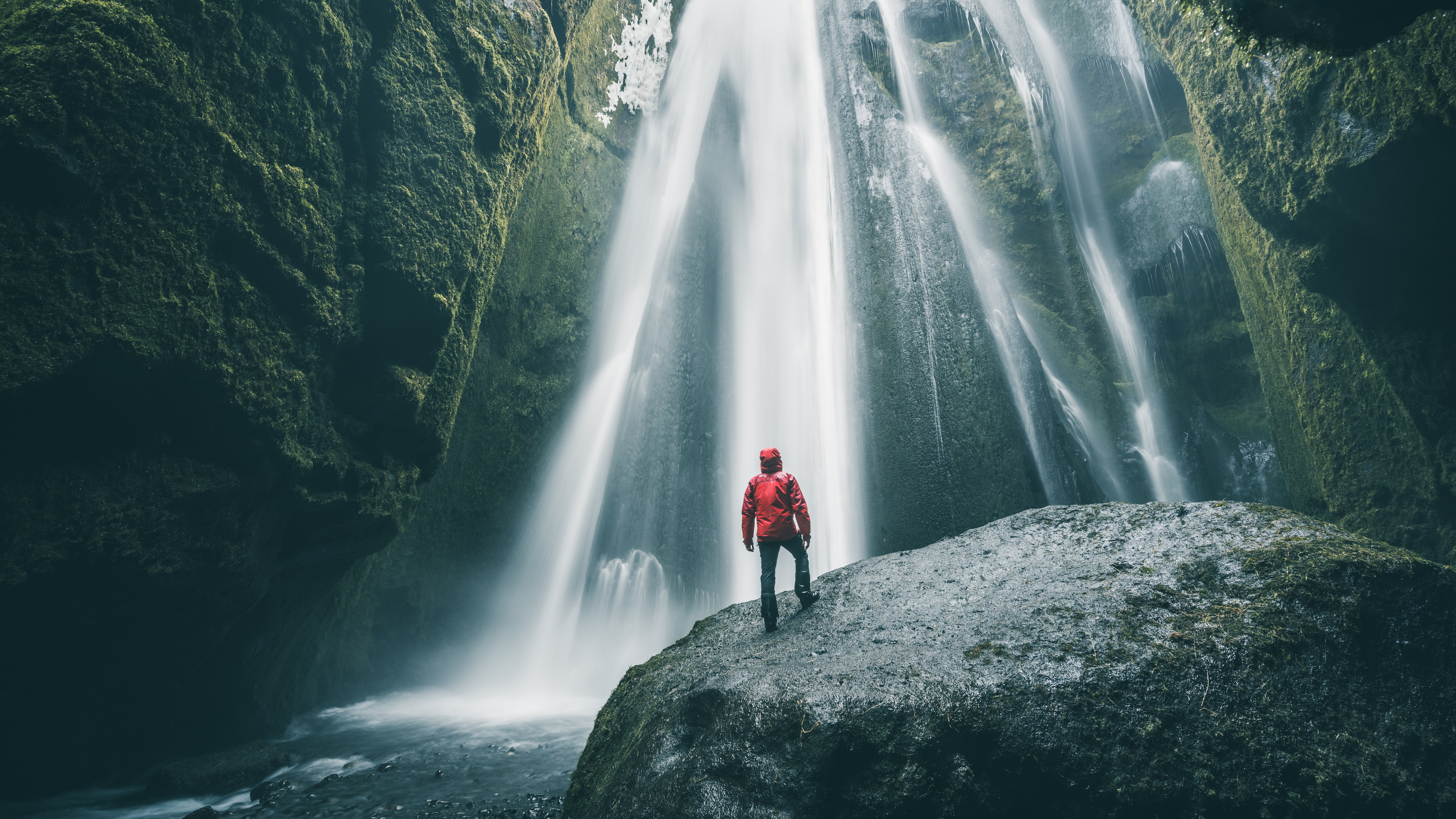 Ein Mann steht vor einem Wasserfall. Das Bild symbolisiert unseren Schwerpunkt Ressourcen.