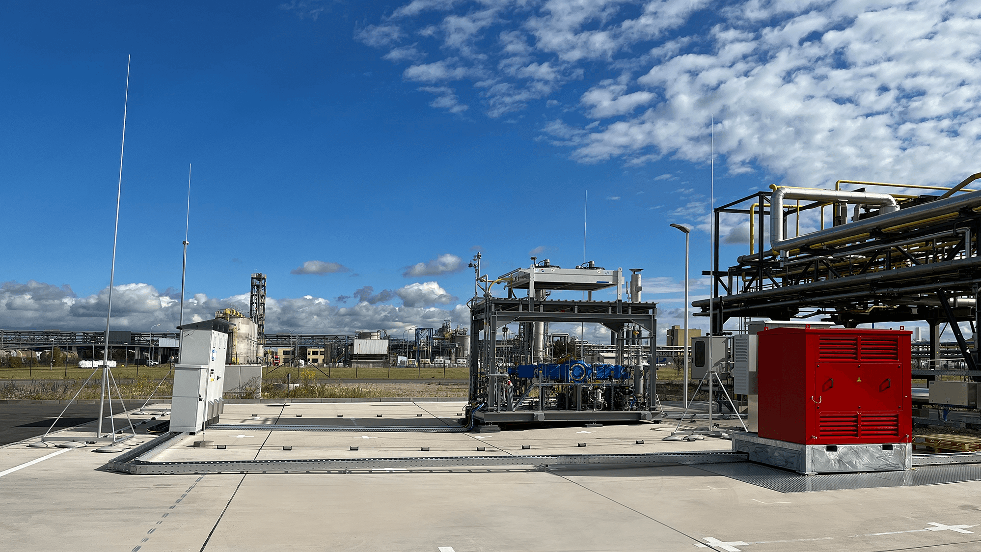 Zu sehen ist ein kompakter Hochdruck-Kolbenverdichter in Container-Bauweise auf dem Testfeld in einer Raffinerie. Dieses Forschungsprojekt dient der Gewinnung von Wasserstoff aus der Elektrolyse.