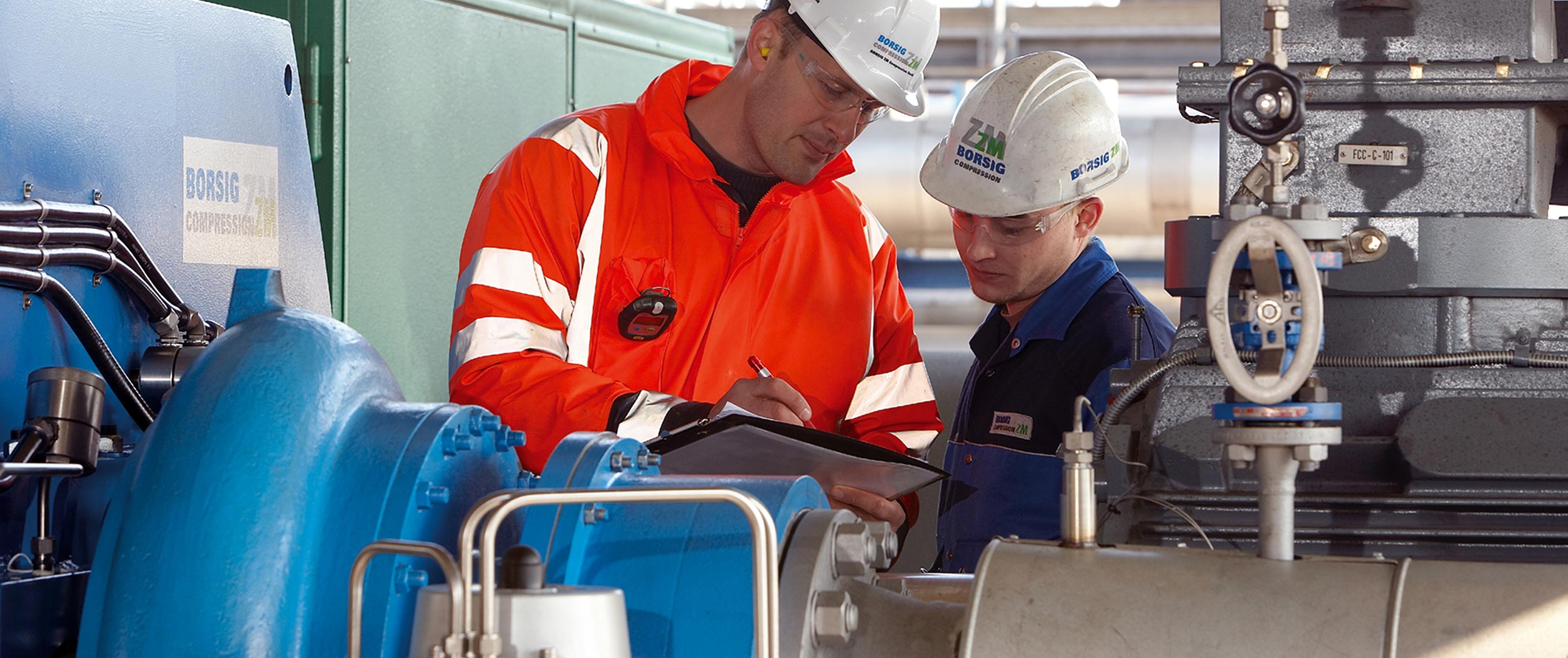 Two BZM employees are shown performing a check-up before the compressor is put into operation at the customer's plant.